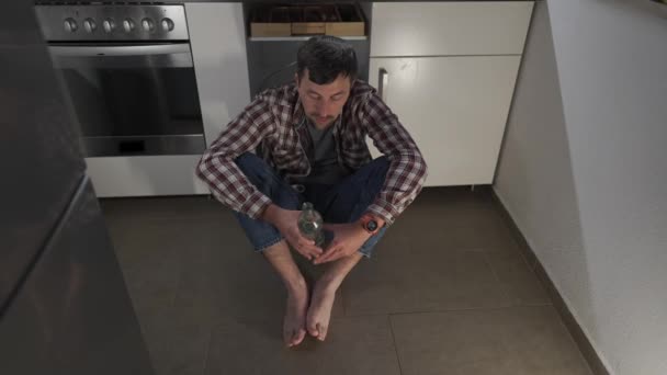 Δυστυχώς Άνθρωπος Μεθυσμένος Από Μπουκάλι Αλκοόλ Στο Πάτωμα Της Κουζίνας — Αρχείο Βίντεο