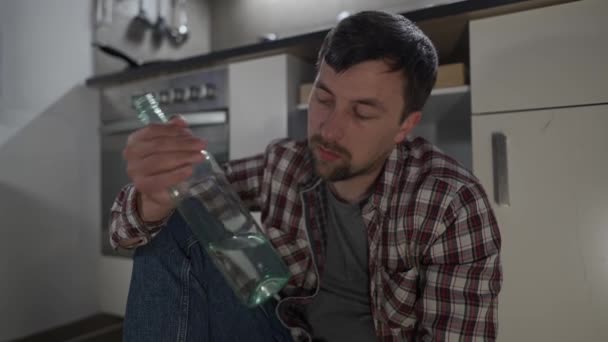Sadly Man Drunk Bottle Alcohol Kitchen Floor House Talking Himself — Vídeo de Stock