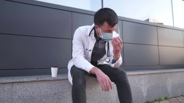 Κουρασμένος Νεαρός Γιατρός Πίνει Καφέ Στο Χώρο Ανάπαυσης Κοντά Στο — Αρχείο Βίντεο