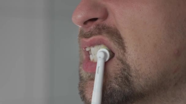 Close Homem Limpeza Dentes Por Uma Escova Dentes Ultra Sônica — Vídeo de Stock