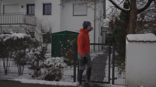 男子跑步者因运动而走出家门 打开音乐 按下运动表开始训练 并开始慢跑 在冬天 德国寒冷的雪天 机灵的手表 开始跑 — 图库视频影像