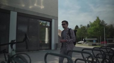 Bicycle protection against theft. Bike street parking for bicycles. Man cyclist unlocks cycle lock from cycle and rides away. Man is unlocking bike on rack outside. Security and anti-theft lock. 