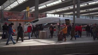 March 20, 2022. Munich. Germany. Deutsche Bahn ICE train stands on the Munich Hauptbahnhof platform and many passengers get off train and walk through the station. Munchen Hbf. Intercity-Express. 
