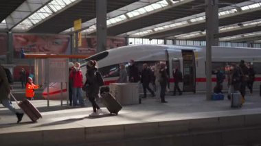 20 Mart 2022. Münih. Almanya. Deutsche Bahn ICE treni Münih Hauptbahnhof platformunda duruyor ve birçok yolcu trenden inip istasyondan geçiyor. Munchen Hbf. Şehirlerarası Ekspres. 