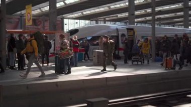 March 20, 2022. Munich. Germany. Deutsche Bahn ICE train stands on the Munich Hauptbahnhof platform and many passengers get off train and walk through the station. Munchen Hbf. Intercity-Express. 