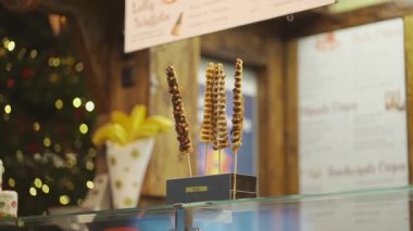 Churros stall at a street food festival at Christmas Market Weihnachtsmarkt in Germany, Munich. Churros for sale in a market. Fast food sweets. Churros street food dessert made from dough and sugar. 
