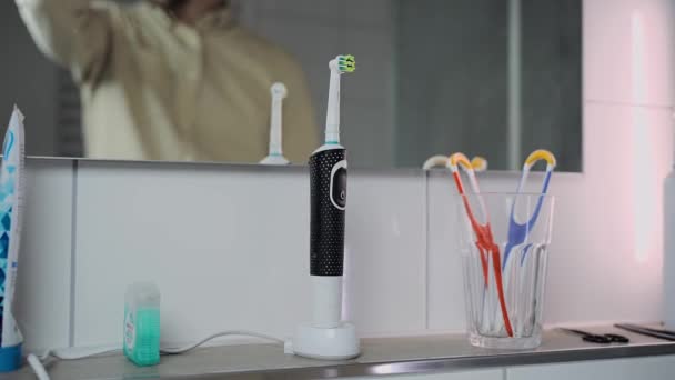 Adam Elektrikli Diş Fırçasını Şarjdan Çıkarır Sabah Işe Gitmeden Önce — Stok video