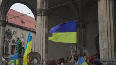 February 18, 2023. Munich. Germany. Odeonsplatz muenchen. Subject of war between Russia and Ukraine. Protesters holding yellow and blue and European Union flags at demonstration against war in Bayern