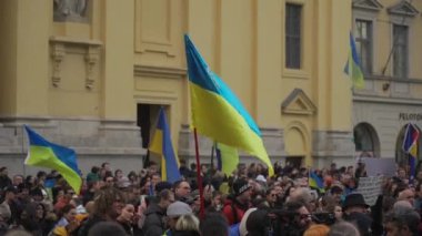 February 18, 2023. Munich. Germany. Odeonsplatz muenchen. Subject of war between Russia and Ukraine. Protesters holding yellow and blue and European Union flags at demonstration against war in Bayern