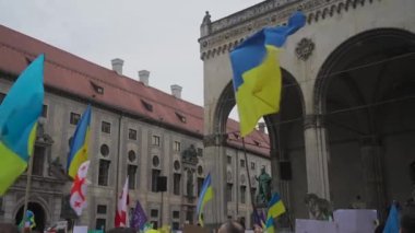 Munich. Germany. Odeonsplatz muenchen. Subject of war between Russia and Ukraine. Protesters holding yellow and blue and European Union flags at demonstration against war in Bayern. 