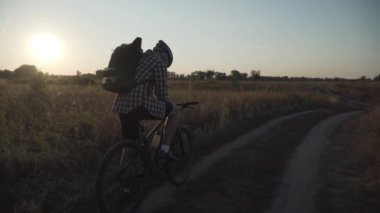 Spor, aktif yaşam tarzı ve modern teknoloji. Motosikletli bir motosikletli, navigatör kullanıyor, haritayı araştırıyor ve kırsalda bisiklet sürerken GPS koordinatlarını araştırıyor. Genel konumlandırma sistemi.