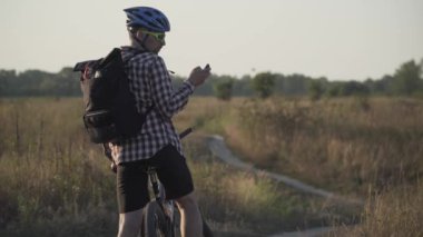 Navigatörlü bir dağ bisikletçisi ekranda bir şey arıyor. Rotayı belirliyorum. Bisikletçi bisiklet bilgisayarı kullanıyor, navigatör sahada. Bisikletçi geriye bakıyor, GPS kullanıyor, en kısa yolu seçiyor.