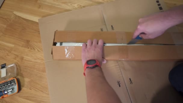 Homem Caixa Papelão Descoberto Peças Com Faca Para Montar Mesa — Vídeo de Stock