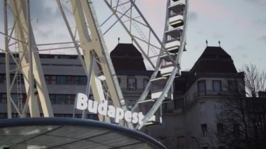 Budapeşte, Macaristan 'da alacakaranlıkta dönme dolap. Elisabeth meydanının alacakaranlıktaki aydınlanmış dönme dolap manzarası. Eğlence parkı kavramı, adil, heyecan verici. Macaristan 'ın başkentine turist gezisi. 