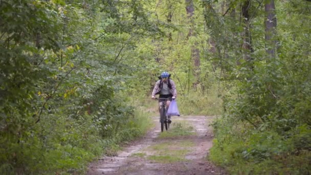 生态问题 在清除污染后 骑自行车的男性骑自行车的人把垃圾袋放在车把上 男子在生态马拉松 清洗塑料瓶和其他垃圾的过程中收集垃圾 — 图库视频影像