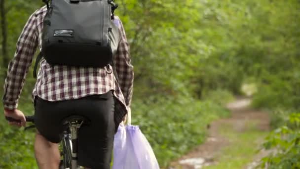 Волонтёр Велосипедист Вывозит Мусорные Мешки Мусора Убирает Лес Время Езды — стоковое видео