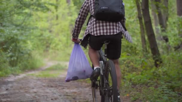 Atleta Bicicletta Attraverso Foresta Con Sacco Della Spazzatura Sul Manubrio — Video Stock