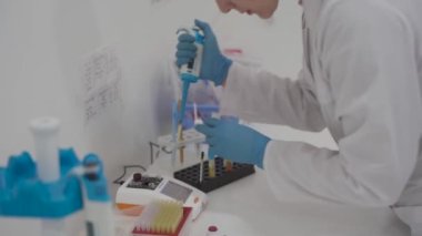 Kan analizi sırasında pipetli bir tıbbi laboratuvar asistanı. Hastane laboratuarlarındaki ekipmanlar. Hematolojik inceleme için damlatıcıyla araştırma görevlisi. Modern laboratuvarda bilim adamı.. 
