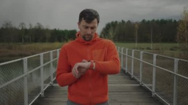 Koşucu spor saatine bakıyor. Atletik koşucu fitness izleyicisi üzerinde çalışmaya başladı. İz sürme ve aktif yaşam tarzı kavramı. Spor, koşu, sağlıklı yaşam tarzı. GPS konumu veya nabzı kontrol ediliyor. 