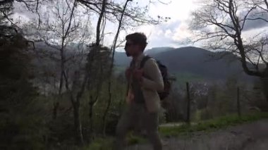 Almanya 'da, Schliersee Gölü yakınlarında gündüz gezisinde sırt çantası ve güneş gözlükleriyle dağlarda yürüyüş yapan bir adam. Seyahat yaşam tarzı ve macera. Kırsalda erkek yürüyüşü. Tema Deutschland 'da seyahat ediyor. 