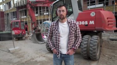 İnşaat alanında buldozer kullanan bir işçi. Erkek kazıcı işçi. İnşaat mühendisi işçi operatörü ve arka planda kazıcı var. Toprak hareket eden bir makine ya da bir binanın önünde dozer taşıyan bir çalışan.. 