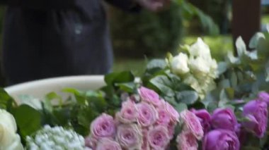 Çiçekçiler biner, düğün töreni için çiçek kemeriyle süslerler. Dekoratörler etkinlikte çalışıyor, doğum günü, yıldönümü, parti. Taze çiçeklerle süslenmiş bir olay. Kırsal tarzda. İşteki tasarımcı.