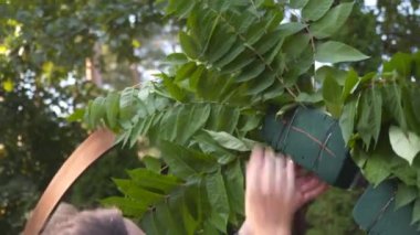 Çiçekçiler biner, düğün töreni için çiçek kemeriyle süslerler. Dekoratörler etkinlikte çalışıyor, doğum günü, yıldönümü, parti. Taze çiçeklerle süslenmiş bir olay. Kırsal tarzda. İşteki tasarımcı.
