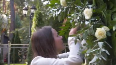 Personel etkinliği ajansı iş başında. Çiçekçiler biner, çiçekleri düğün töreni için kemerle süslerler. Profesyonelce düğün dekorasyonu yaratmak. Çiçekçilik. Düğün kemeri için çiçek kompozisyonuyla çalışan bir dekoratör
