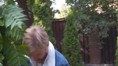 Profesyonel çiçekçi düğün kaydı için festival kemerini dekore ediyor. Kadın düğün dekoru kuruyor. Dekoratör, açık hava düğün törenini çiçekler ve yeşilliklerle süslüyor..