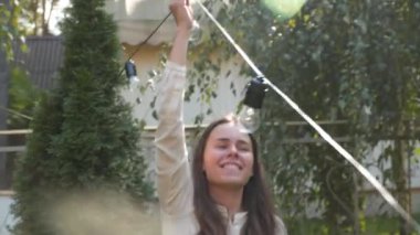 Kadın dekoratör bahçede yapılacak düğün törenleri için siyah tel çelenkler hazırlıyor. Kadın tasarımcı açık hava ışığını düğün töreni için hazırlıyor. Düğün kemerinde çiçekler ve lambalar ile dekorasyon. 