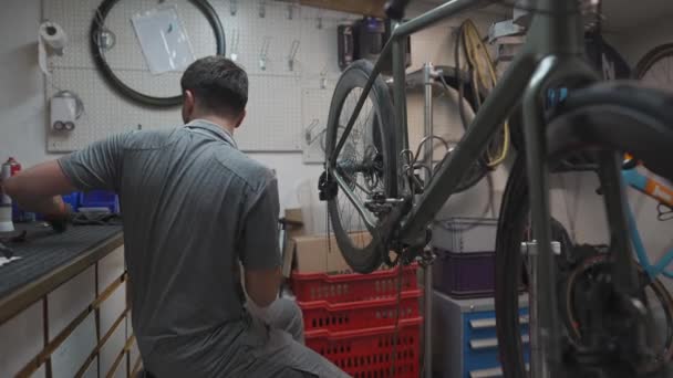 人力自行车技工在自行车上安装自行车链条 技师在自行车修理店修理自行车链条齿轮 自行车技工调整自行车链条 车间机械工程师固定传动 — 图库视频影像