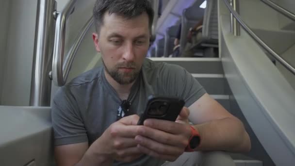 젊은이는 열차를 스마트폰을 사용하여 전단에 앉는다 여행중에 수있는 중갑판 열차에 — 비디오
