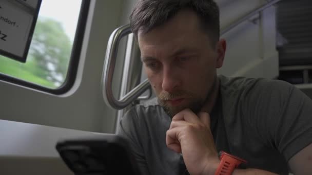 年轻人乘双层火车旅行 用智能手机坐在传单上 在铁路旅行中没有空位 乘坐双层列车的男性通勤者坐在传单和网上冲浪 — 图库视频影像