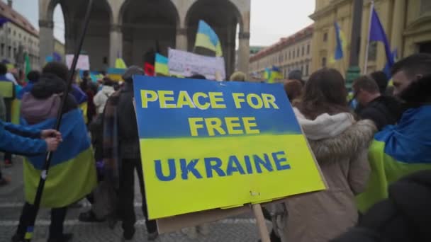 在德国慕尼黑Odeonsplatz举行的反对乌克兰战争的示威期间 在蓝色黄色海报 和平为了自由的乌克兰 上签名 集会抗议乌克兰战争的标语和标语 — 图库视频影像