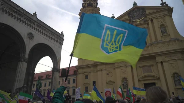 Munich. Germany. Odeonsplatz muenchen. Subject of war between Russia and Ukraine. Protesters holding yellow and blue and European Union flags at demonstration against war in Bayern. 