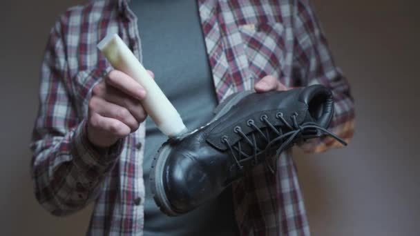 Άνθρωπος Βάζει Προστατευτικό Λάδι Στις Χειμερινές Του Μπότες Για Προστασία — Αρχείο Βίντεο