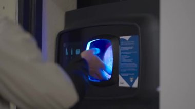 Adam süpermarket otomatındaki plastik şişeleri iade ediyor. Plastiğin parasını mağazadaki otomatik şeker şişelerine geri ödeyen bir erkek. Geri dönüşüm makinesi. Plastik için makinelerden para al. 