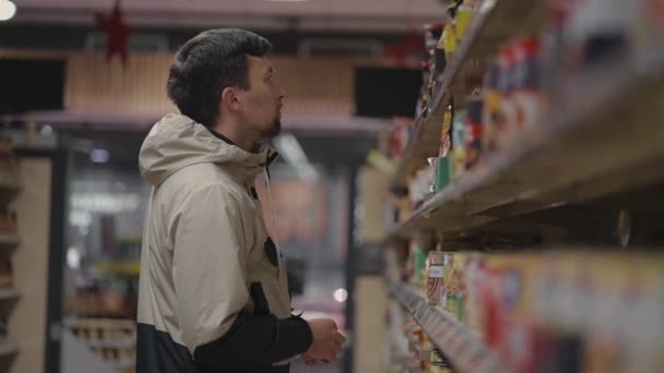 식료품 가게에서 식료품을 손님은 선반에서 가져온 식품에 재료들을 읽는다 상품의 — 비디오