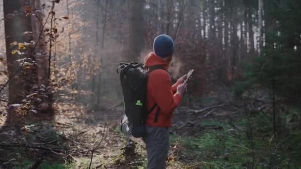 徒步旅行时的户外地图 Hiker使用智能手机通过应用程序制图在森林中导航 用智能手机来旅行路线 旅行者用全球定位系统在树林中航行 探险和远足 — 图库视频影像