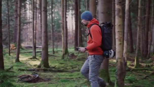 Vandrare Som Använder Mobil Applikation För Att Navigera Höstskogen Pathfinder — Stockvideo