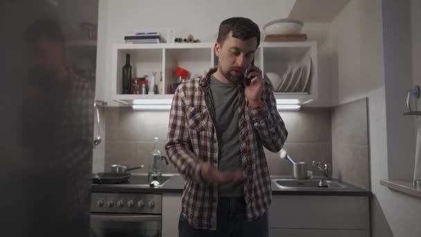Gefrustreerde Ongelukkige Man Die Thuis Met Smartphone Keuken Spreekt Een — Stockvideo