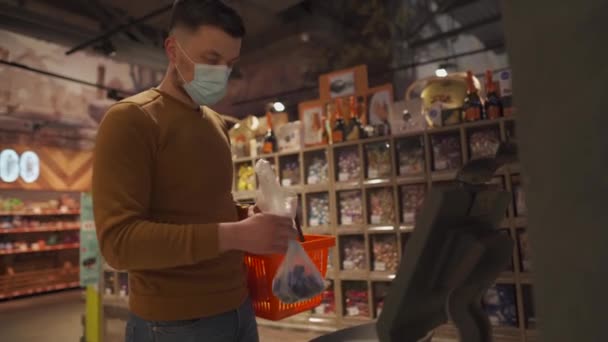 Mannelijke Shopper Met Een Beschermend Masker Weegt Goederen Een Zak — Stockvideo