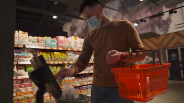 Człowiek Masce Waży Słodycze Skalę Elektroniczną Supermarkecie Wybiera Pożądany Produkt — Wideo stockowe