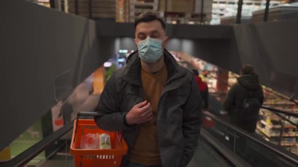 Mand Beskyttende Maske Med Indkøbskurv Hænderne Bevæger Rulletrappe Stort Købmandssupermarked – Stock-video
