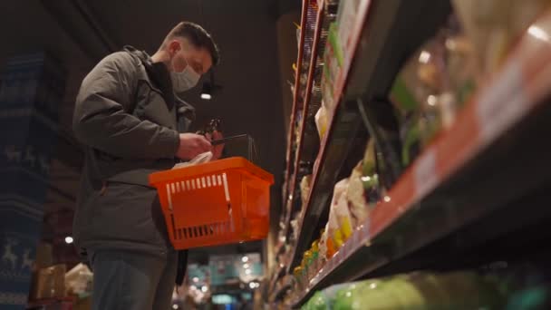 Молодой Кавказский Человек Маске Выбирает Молочные Продукты Супермаркете Время Пандемии — стоковое видео