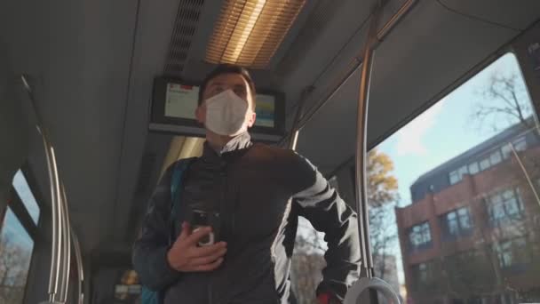在慕尼黑 一个戴着面具乘坐电车旅行的年轻人 德国公共交通上的蒙面乘客 在欧洲有轨电车内戴防护面具的男性 蒙琴的Strassenbahn — 图库视频影像