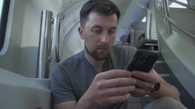 Erkek, merdivenlerde oturup internette gezinen ikiz trene biner. Çift katlı demiryolu treninde seyahat eden bir adam merdivende oturur çünkü Avrupa 'da boş koltuk yoktur. İki katlı tren yolculuğu.