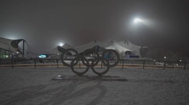 Olimpiyat oyunları, Münih, Almanya 'da Olimpiyat Parkı' nda karlı bir akşamda logoda. Olympia Muenchen 'deki bir parkta karların içinde yüzüyor. Olympiapark Münih. Olimpiyat Çemberi. 