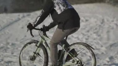 Erkek bisikletçi kışın Münih, Almanya 'da güneşli bir havada parkta bisiklet sürüyor. Her türlü havada bisikletle gidip geliyor. Açık hava kış aktiviteleri. Kışın çevre dostu ulaşım. 