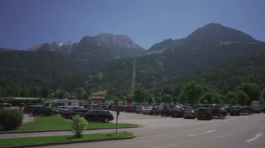 Schonau am Konigssee, Almanya. Açık hediyelik eşya dükkanları, sokak kafeleri ve yürüyen turistlerle merkez meydanı manzarası. İnsanlar küçük dağlardaki dağlarda Avrupa caddelerinde geziniyor.. 